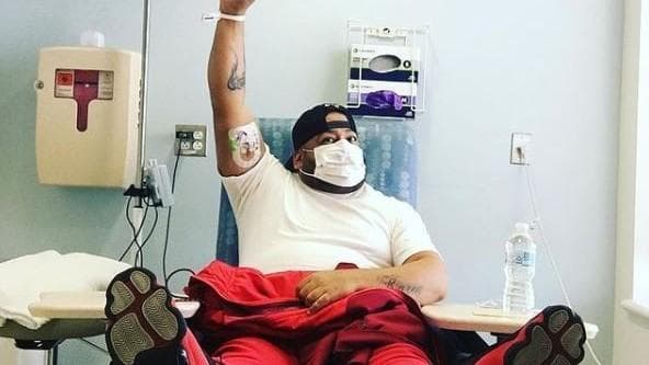 Hot 97's Luis "Pretty Lou" Ortega standing proudly in front of the DKMS logo after battling and defeating his aplastic anemia and leukemia diagnosis.